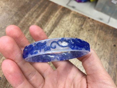 Lot 110 - A CHINESE BLUE-OVERLAY BEIJING GLASS 'CHILONG' BANGLE