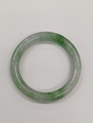 Lot 536 - A CHINESE PALE-CELADON AND APPLE-GREEN JADE BANGLE