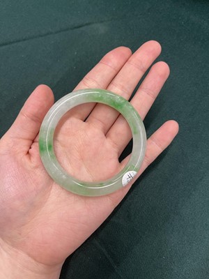 Lot 734 - A CHINESE PALE-CELADON AND APPLE-GREEN JADE BANGLE