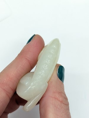 Lot 520 - A CHINESE WHITE JADE 'DOG' CARVING