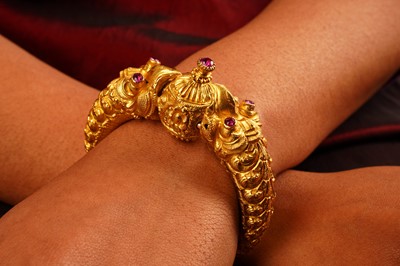 Lot 298 - A RUBY-SET 'MAKARA HEAD' GOLD BANGLE (KADA)