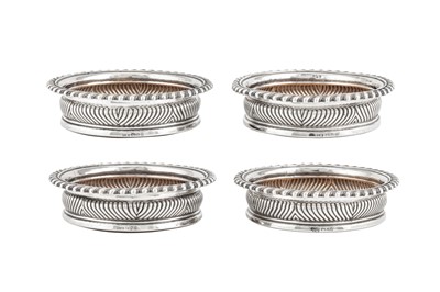 Lot 494 - A set of four George III sterling silver wine coasters, Sheffield 1819 by John Watson and Co