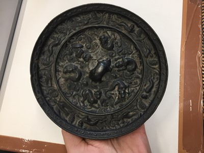 Lot 518 - A CHINESE BRONZE 'LIONS AND GRAPES' MIRROR