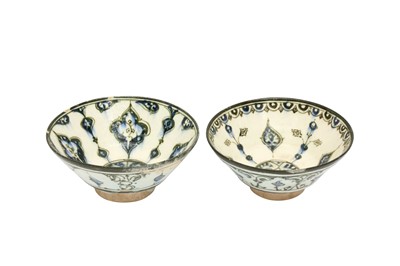 Lot 4 - A NEAR PAIR OF COBALT BLUE AND BLACK-PAINTED POTTERY BOWLS WITH ARABESQUE MOTIFS