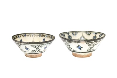 Lot 4 - A NEAR PAIR OF COBALT BLUE AND BLACK-PAINTED POTTERY BOWLS WITH ARABESQUE MOTIFS