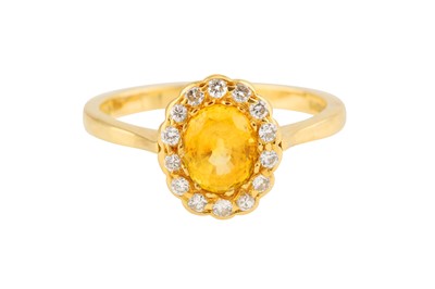 Lot 121 - A YELLOW SAPPHIRE AND DIAMOND CLUSTER RING