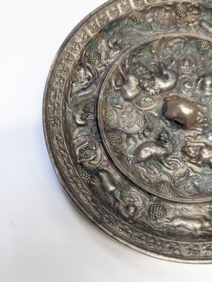 Lot 221 - A CHINESE SILVERED BRONZE 'LION AND GRAPEVINE' MIRROR