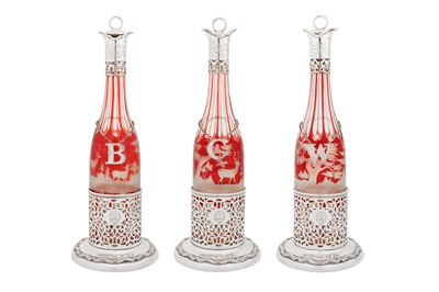 Lot 368 - A good set of three Victorian sterling silver mounted cased ruby glass decanters with bottle stands, Sheffield 1857 by James and Nathaniel Creswick