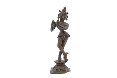 Lot 125 - A SOUTH INDIAN POLYCHROME-PAINTED BRONZE FIGURINE OF LORD KRISHNA PLAYING THE FLUTE