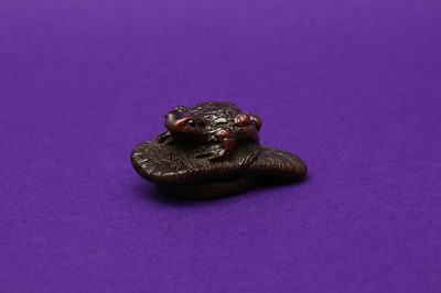 Lot 1021 - A JAPANESE WOOD NETSUKE OF A TOAD ON A SLIPPER