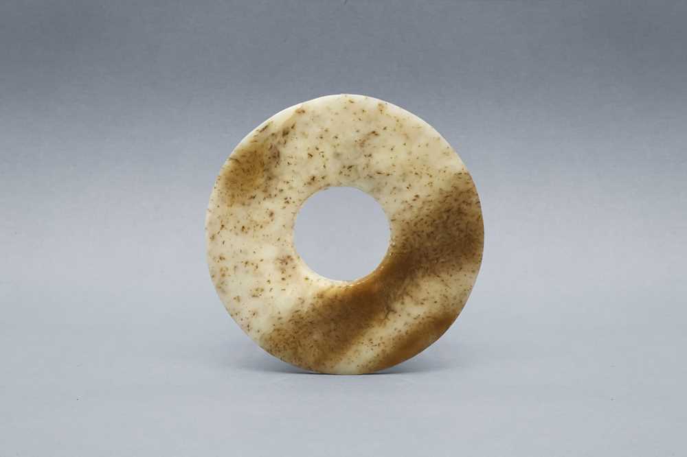 Lot 360 - A SMALL CHINESE ARCHAIC MOTTLED JADE DISC, BI