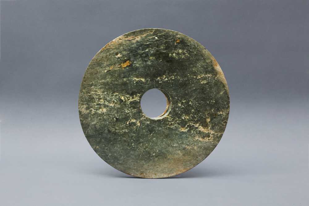Lot 374 - A LARGE CHINESE ARCHAIC MOTTLED GREEN JADE DISC, BI