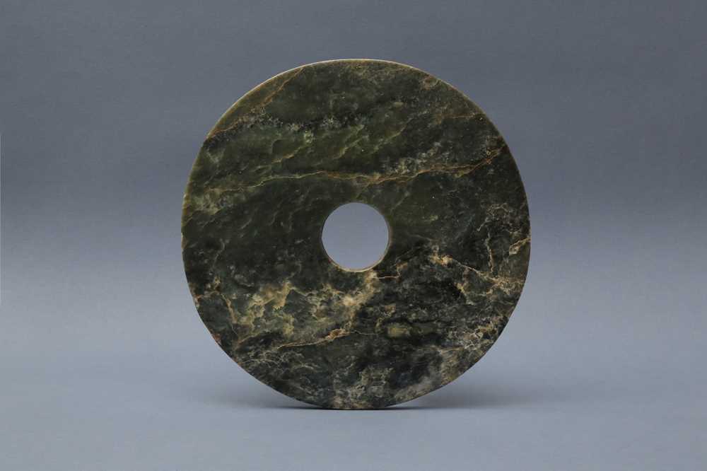 Lot 373 - A LARGE CHINESE ARCHAIC MOTTLED GREEN JADE DISC, BI