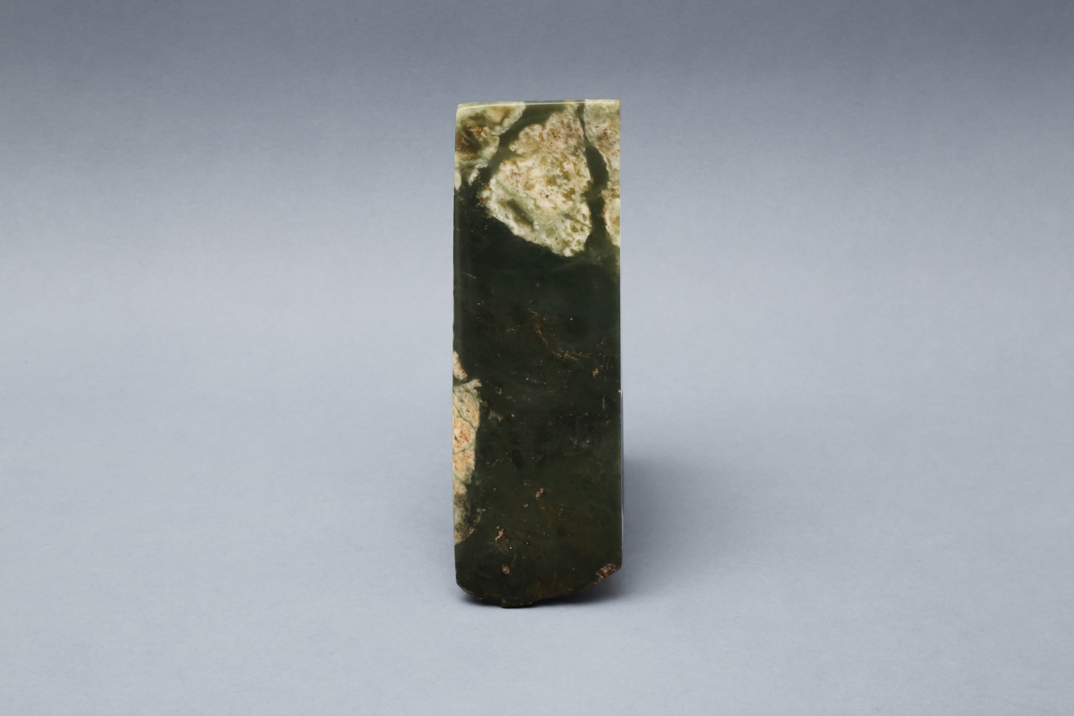 Lot 414 - A CHINESE ARCHAIC SPINACH-GREEN JADE AXE