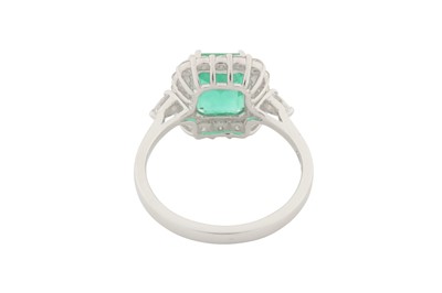 Lot 94 - A DIAMOND AND EMERALD CLUSTER RING