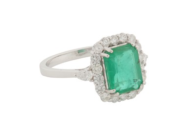 Lot 94 - A DIAMOND AND EMERALD CLUSTER RING