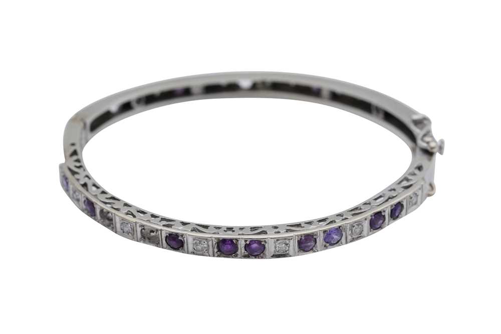 Lot 345 - A DIAMOND AND AMETHYST BANGLE