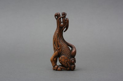 Lot 417 - A JAPANESE BOXWOOD NETSUKE OF A MYTHICAL KIRIN, AFTER TOMOTADA