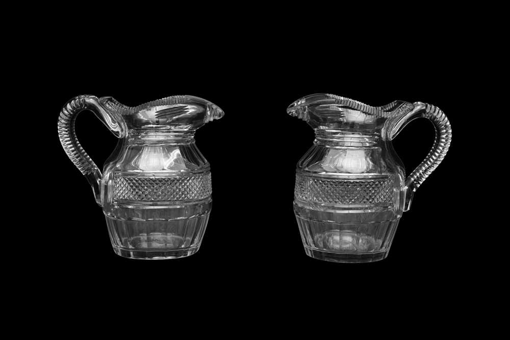 Lot 44 - A PAIR OF REGENCY GLASS WATER JUGS OF HELMET SHAPE, CIRCA 1800