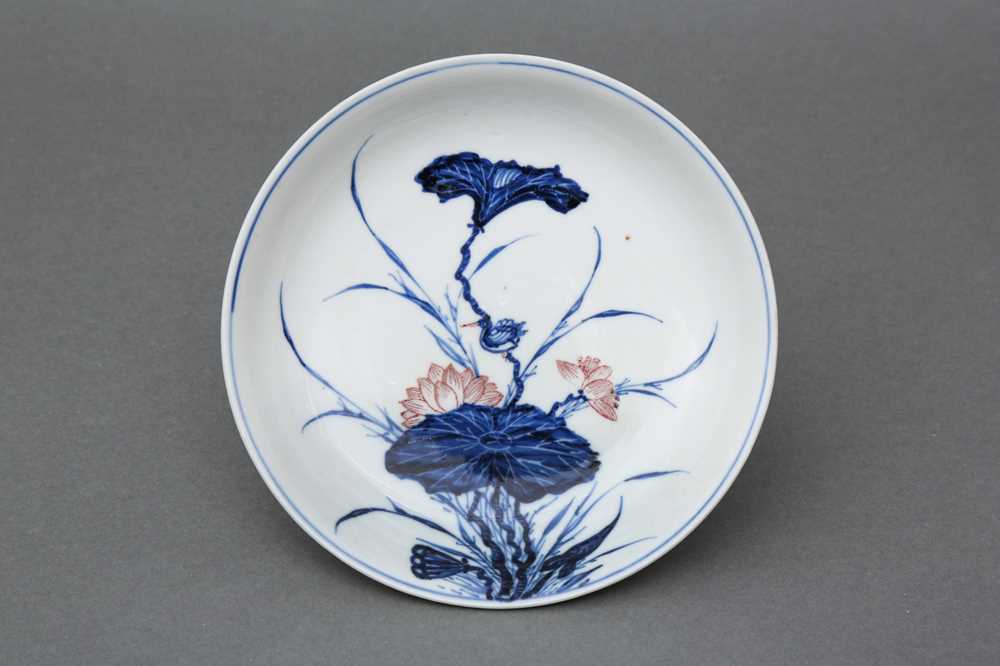 Lot 17 - A RARE CHINESE BLUE AND WHITE AND COPPER-RED 'LOTUS AND EGRET' DISH