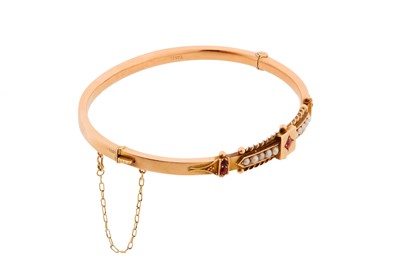 Lot 25 - A 9CT ROSE GOLD GEM-SET AND SEED PEARL BANGLE