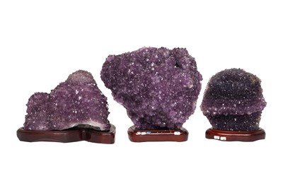 Lot 230 - THREE AMETHYST GEODE CLUSTERS ON STANDS