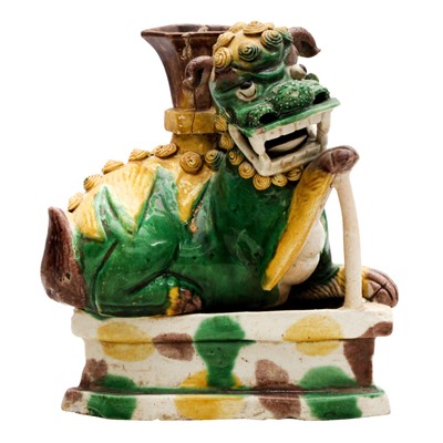 Lot 426 - A Chinese biscuit sancai-glazed 'lion dog' candle holder, Qing dynasty, Kangxi period