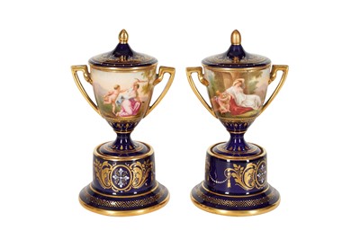 Lot 150 - A PAIR OF SMALL BLUE VIENNA PORCELAIN TWIN HANDLED VASES WITH PAINTED RESERVES