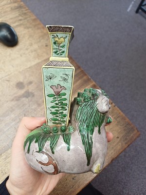 Lot 13 - A CHINESE BISCUIT FAMILLE-VERTE 'LION DOG' CANDLE HOLDER