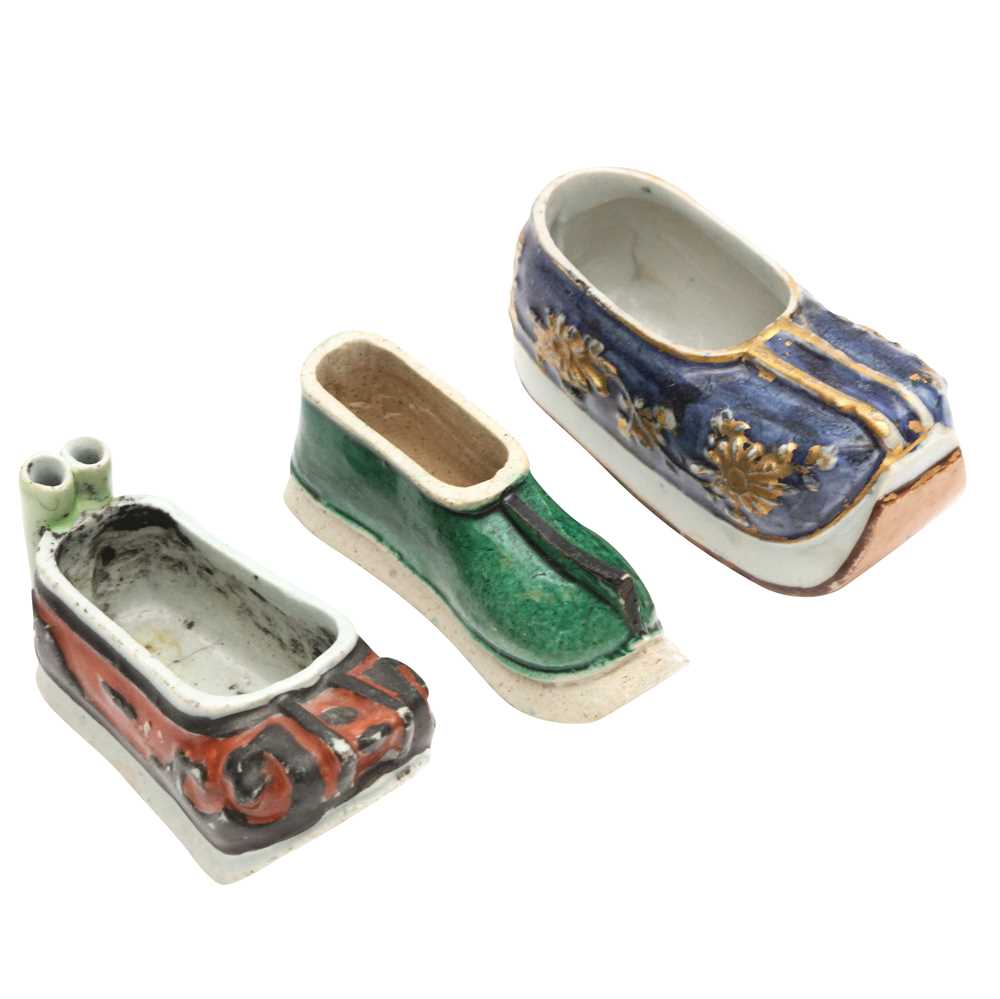 Lot 425 - Three Chinese biscuit famille-verte models of shoes, Qing dynasty, Kangxi period