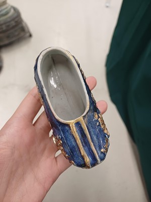 Lot 425 - Three Chinese biscuit famille-verte models of shoes, Qing dynasty, Kangxi period