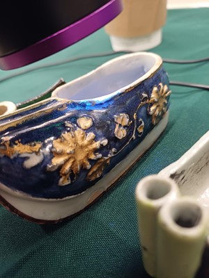 Lot 425 - Three Chinese biscuit famille-verte models of shoes, Qing dynasty, Kangxi period