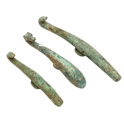 Lot 517 - Three Chinese archaic bronze belt hooks, Western Zhou dynasty