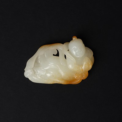Lot 98 - A Chinese pale-celadon and russet jade 'boy' carving, Qing dynasty