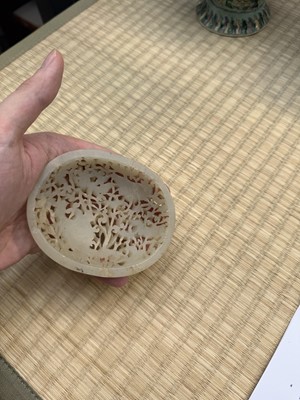 Lot 82 - A Chinese Yuan-style celadon jade reticulated cover, late Ming / early Qing dynasty