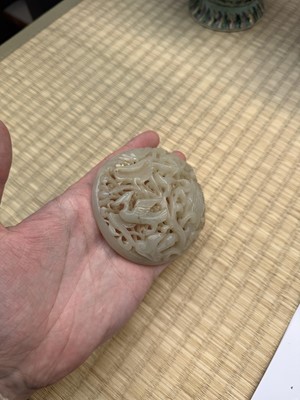 Lot 82 - A Chinese Yuan-style celadon jade reticulated cover, late Ming / early Qing dynasty