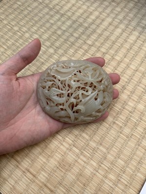 Lot 82 - A Chinese Yuan-style celadon jade reticulated cover, late Ming / early Qing dynasty