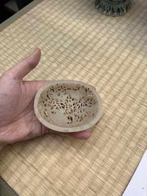 Lot 82 - A Chinese Yuan-style celadon jade reticulated cover, late Ming / early Qing dynasty