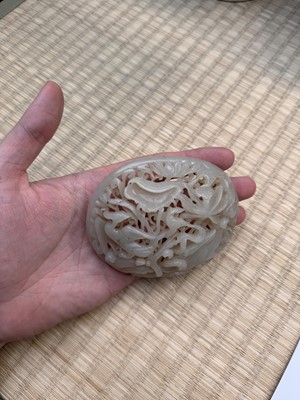 Lot 82 - A Chinese Yuan-style celadon jade reticulated cover, late Ming / early Qing dynasty