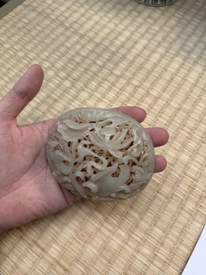 Lot 82 - A Chinese Yuan-style celadon jade reticulated cover, late Ming / early Qing dynasty