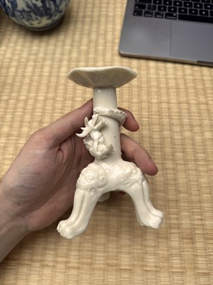 Lot 32 - A Chinese Dehua 'dragon' tripod candlestick, Qing dynasty, Kangxi period