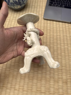 Lot 32 - A Chinese Dehua 'dragon' tripod candlestick, Qing dynasty, Kangxi period