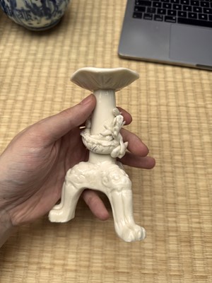 Lot 32 - A Chinese Dehua 'dragon' tripod candlestick, Qing dynasty, Kangxi period