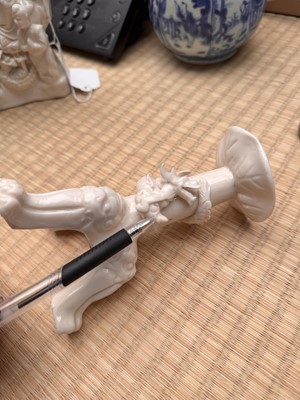 Lot 32 - A Chinese Dehua 'dragon' tripod candlestick, Qing dynasty, Kangxi period