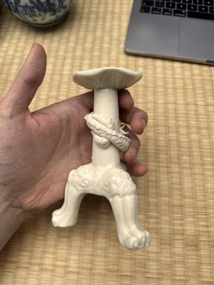 Lot 32 - A Chinese Dehua 'dragon' tripod candlestick, Qing dynasty, Kangxi period