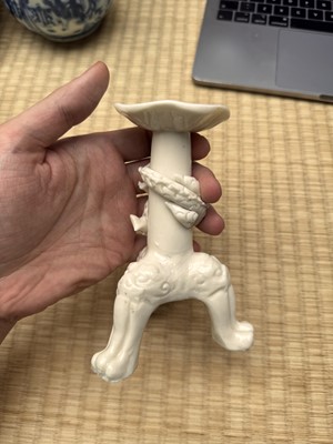 Lot 32 - A Chinese Dehua 'dragon' tripod candlestick, Qing dynasty, Kangxi period