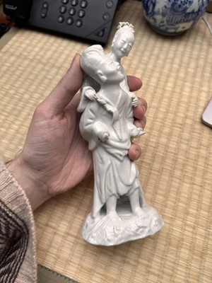 Lot 37 - A Chinese blanc-de-chine 'piggyback' figure group, Qing dynasty, Qianlong period, circa 1760