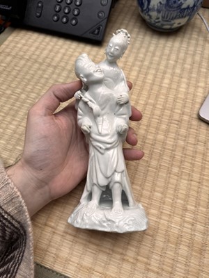 Lot 37 - A Chinese blanc-de-chine 'piggyback' figure group, Qing dynasty, Qianlong period, circa 1760