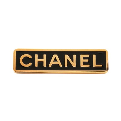 Lot 323 - Chanel Black 'CHANEL' Plaque Brooch