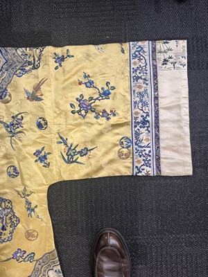 Lot 395 - A fine Chinese yellow-ground embroidered silk robe, Qing dynasty, 19th Century